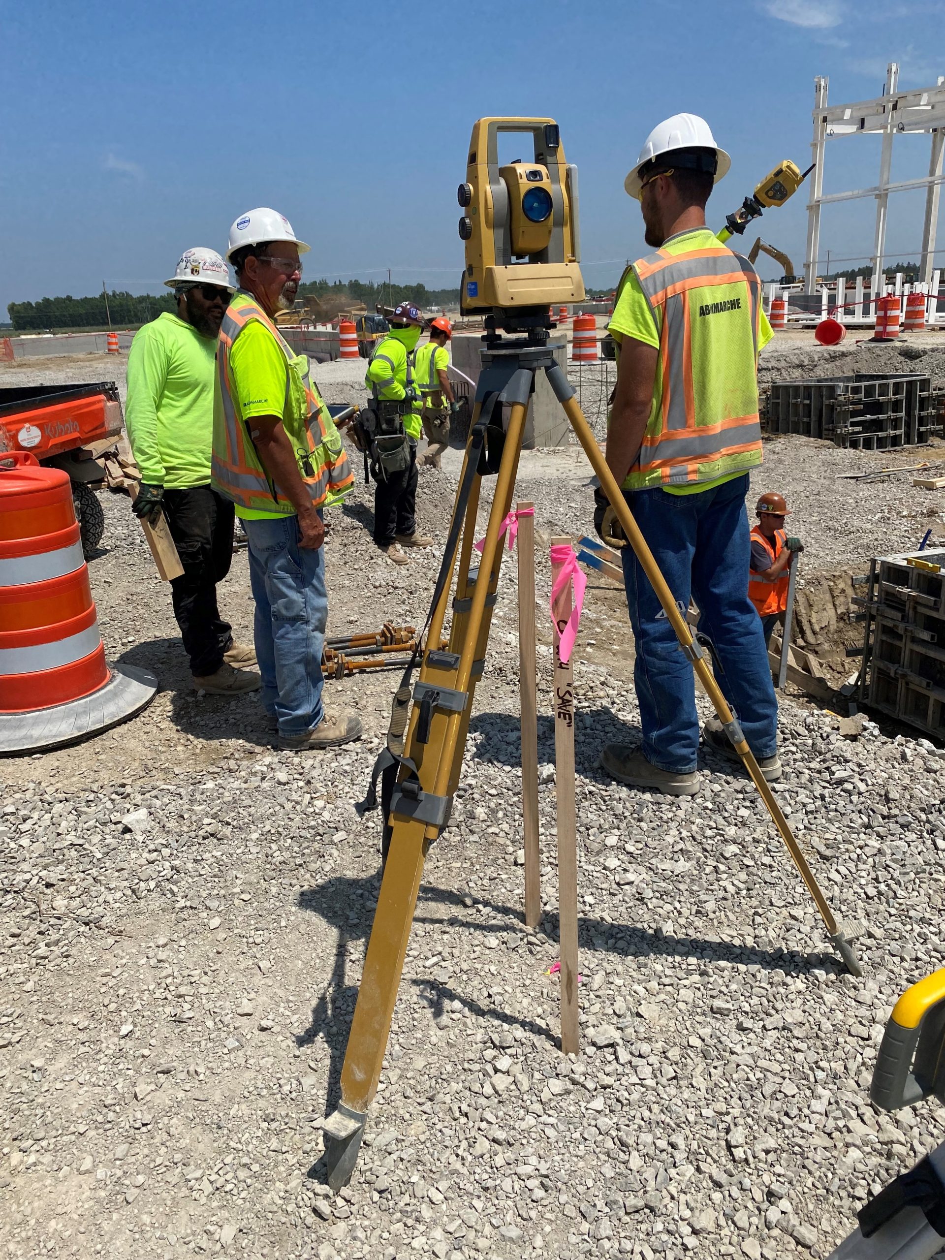 Abonmarche staff conducting field survey with surveying equipment on site